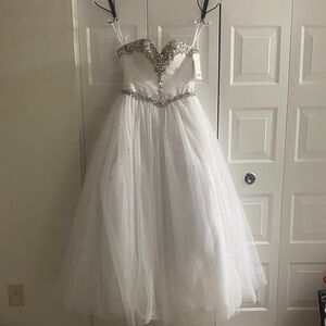 A brand new strapless sweetheart neckline white wedding dress in a size 4.